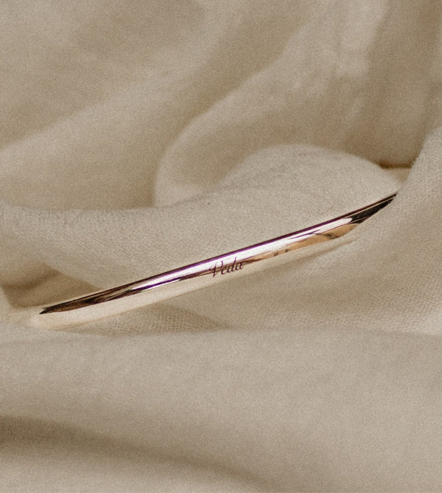 Engraved Boobie Bracelet resting on muslin