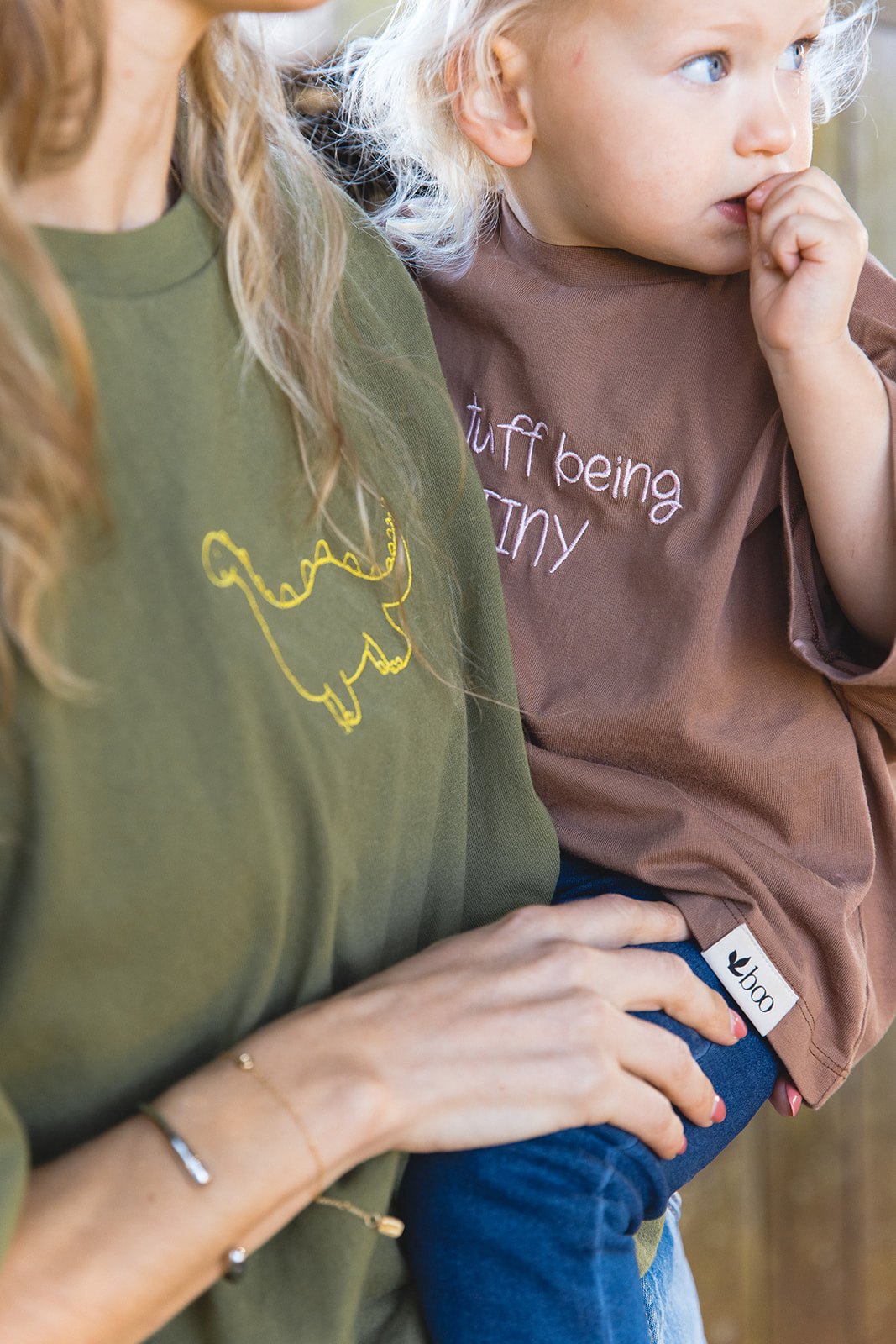 A close look at the embroidered drawing on a green Momenta tee