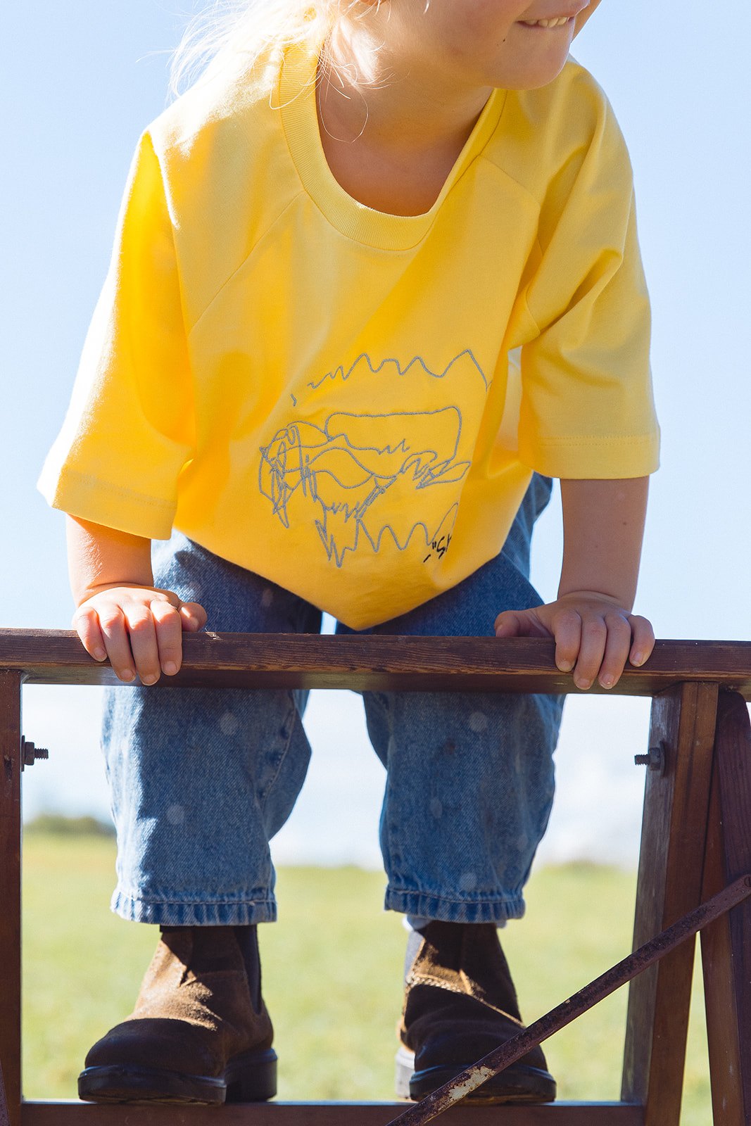 A child wearing a yellow Momenta tee